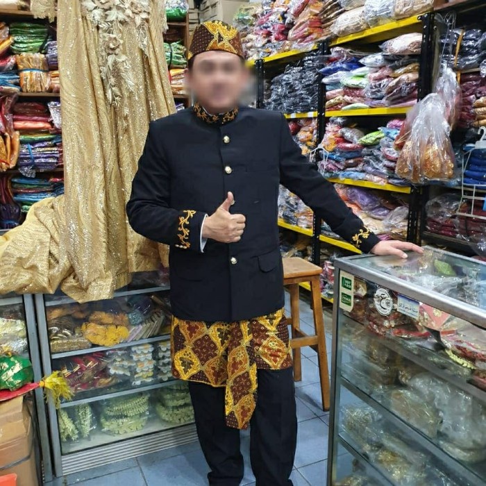 Pria Betawi mengenakan demang dengan kain ujung serong dan hiasan emas