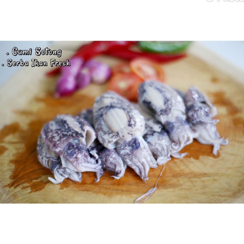 Cumi sotong segar dalam wadah plastik di atas meja kayu