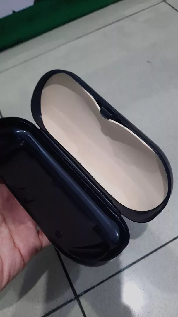 Kompartemen interior lapang memuat frame kacamata baca dan kacamata hitam